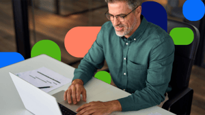 Mann sitzt am Schreibtisch und arbeitet am Laptop
